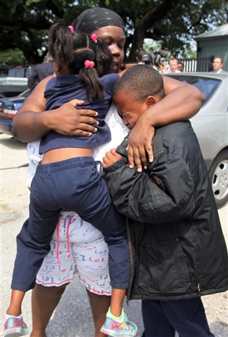 Evette Davis hugs her daughter Heaven, 5, and son Julian, 9, after a shooting at Ross Elementary school on Tuesday in Houston. A kindergartener who brought a loaded gun to his Houston elementary school Tuesday was among three students injured by fragments when it fired after falling from his pocket as he sat down for lunch, officials said. 